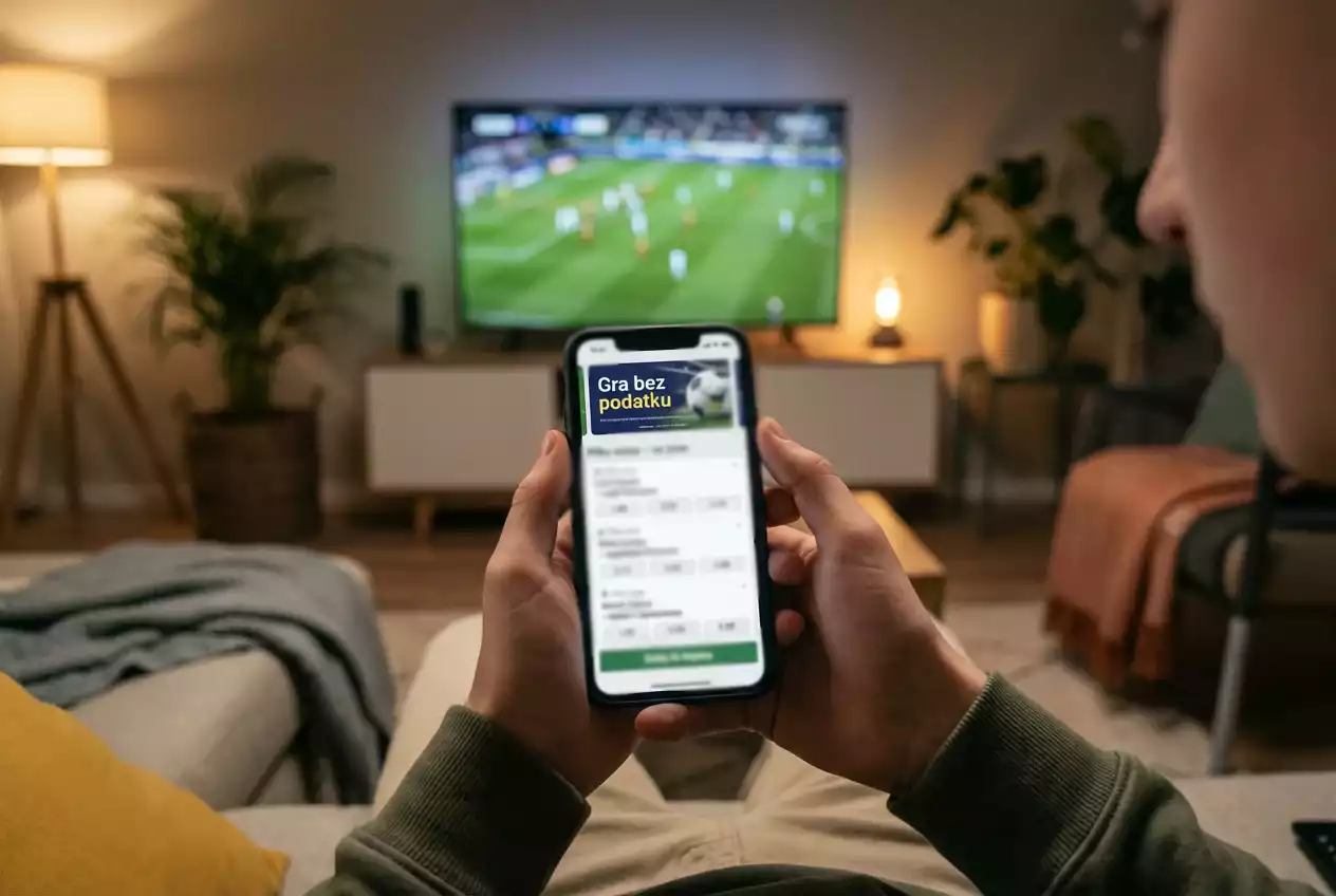 Smartfon z aplikacją Betclic w dłoniach osoby oglądającej mecz